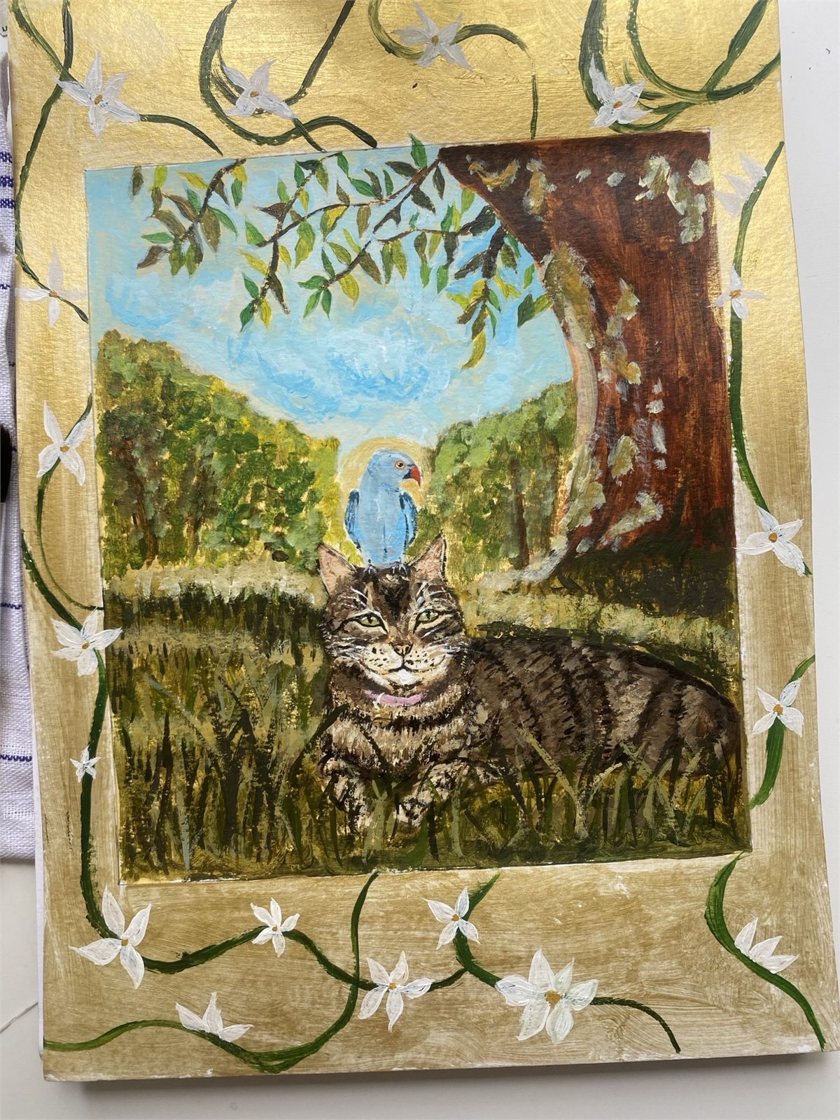 Sarah's gold-framed painting of a tabby cat with a blue bird