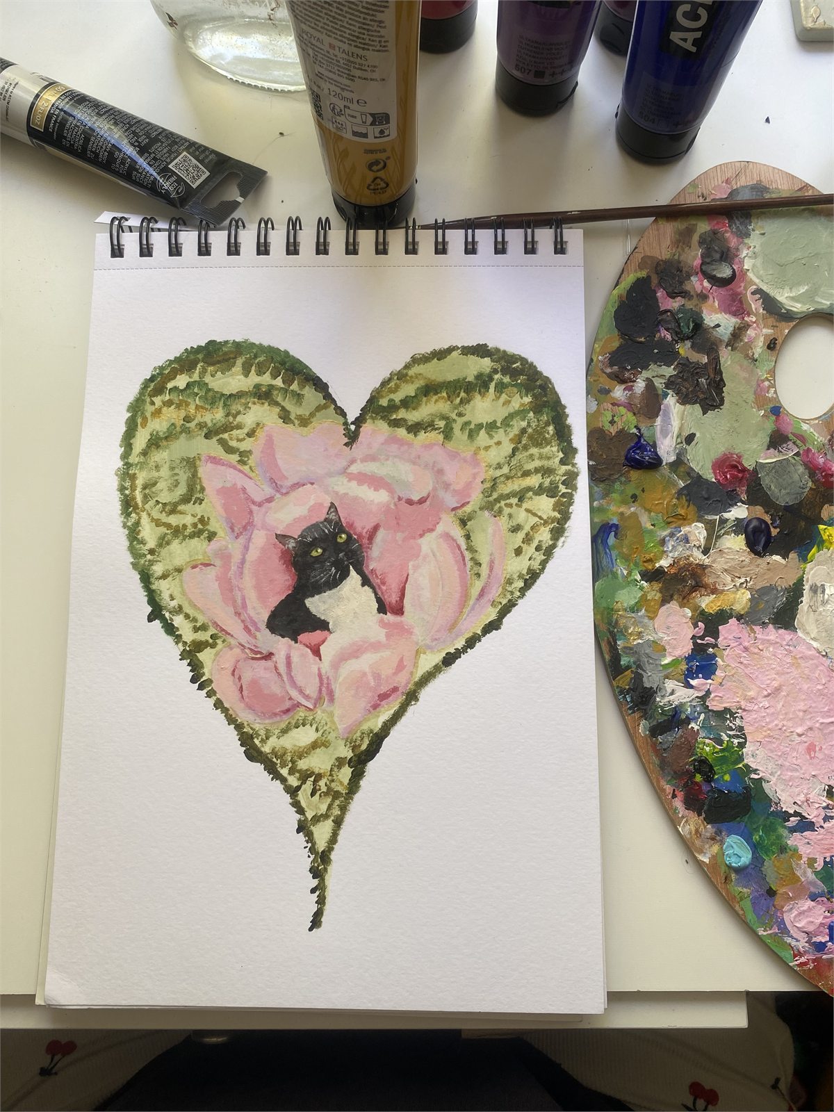 Sarah's painting of a black and white cat inside a pink flower heart