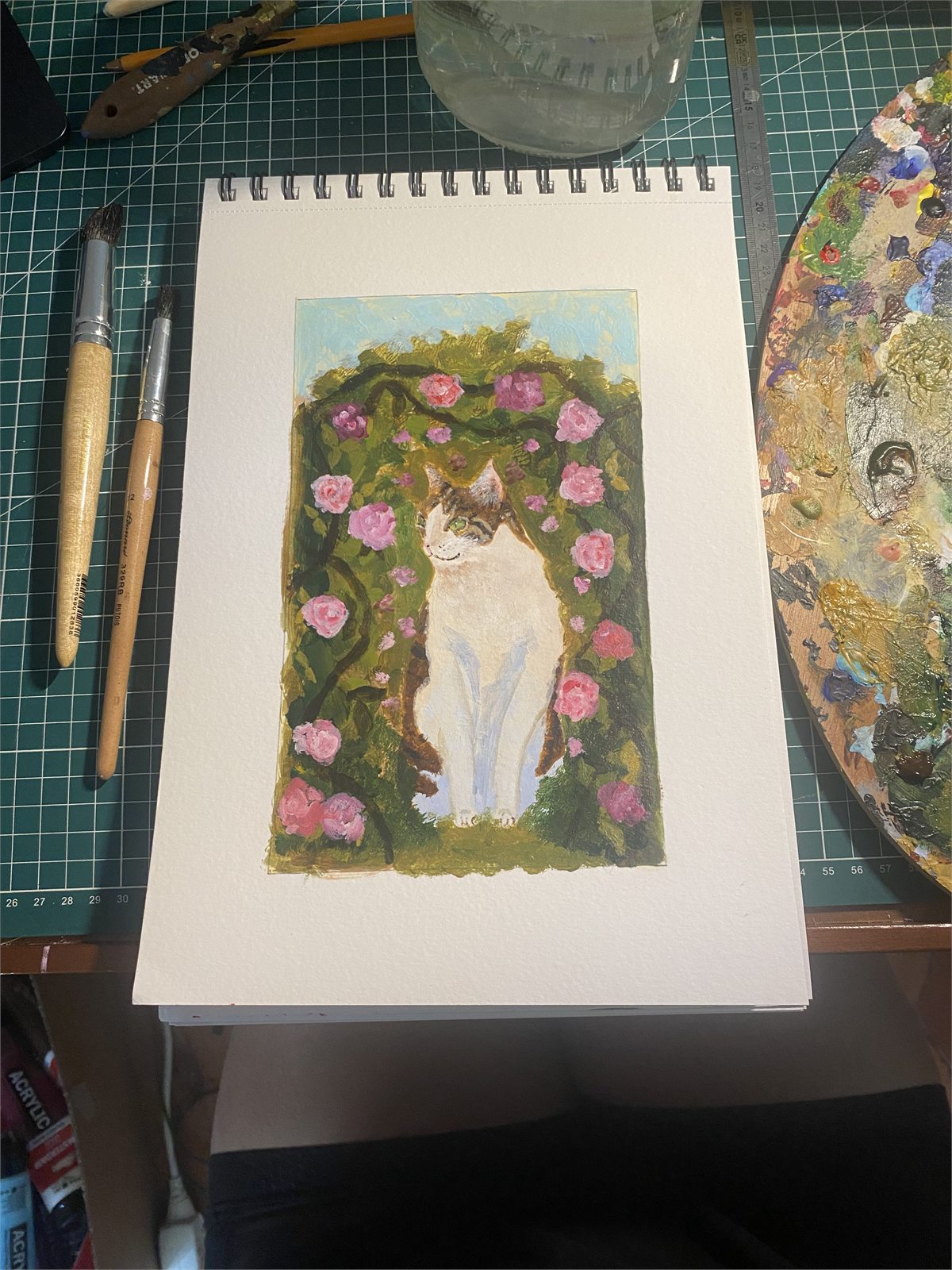 Sarah's painting of a white and tabby cat among pink roses